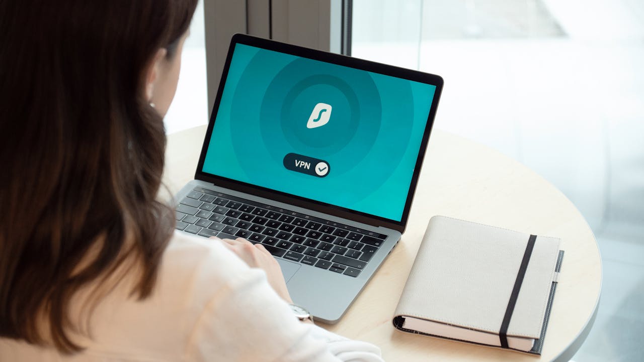 A woman working on a laptop with a VPN icon on screen for secure online browsing.